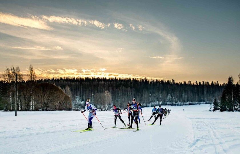 Skidåkare i ett vinterlandskap under ett långlopp på skidor